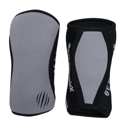 Gray Sharkskin Bear KompleX knee sleeves shown on a model, designed for support and compression during workouts.