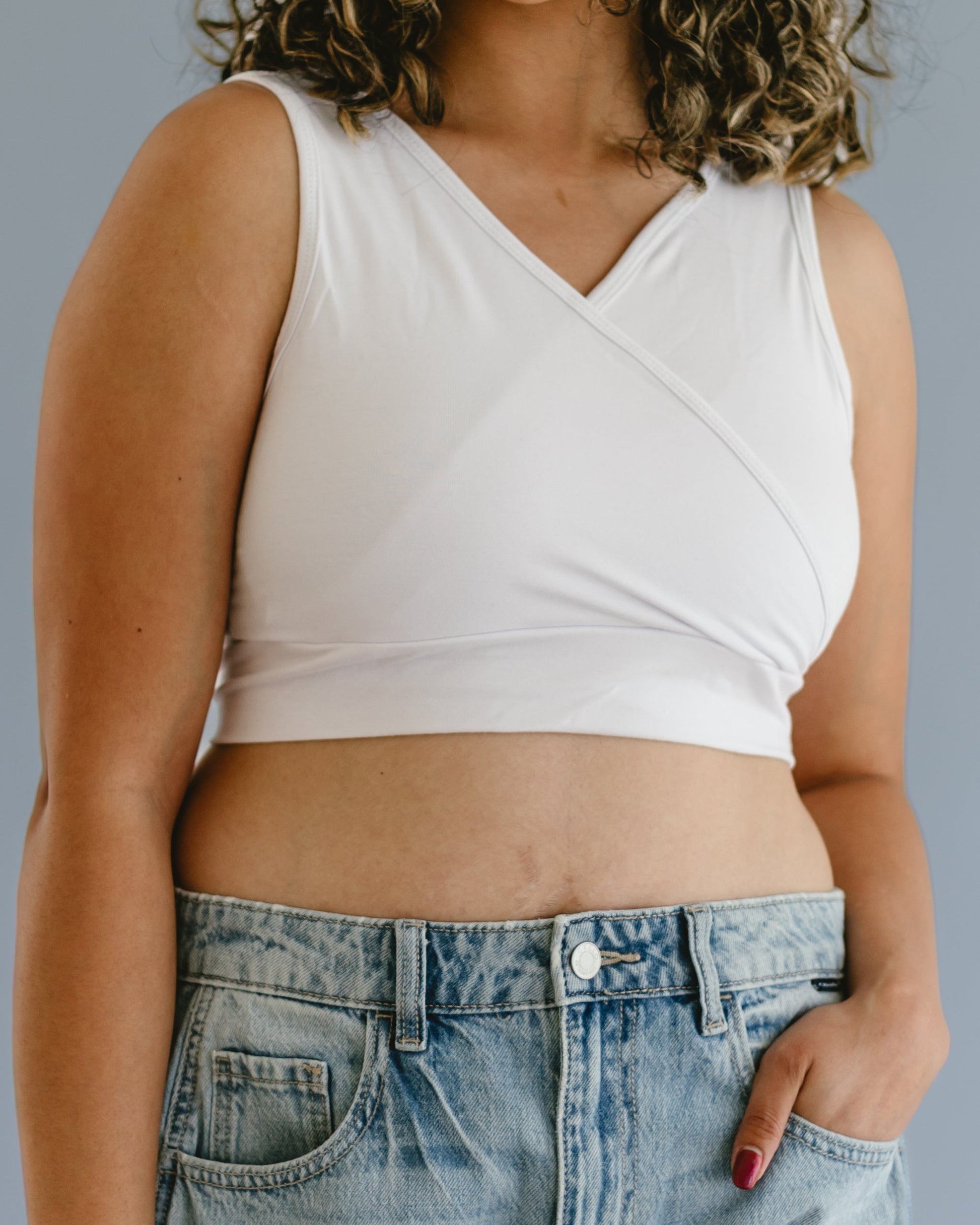 White crossover tank top by HALFTEE Layering Fashions with side pockets for insertable cups, shown on a mannequin.