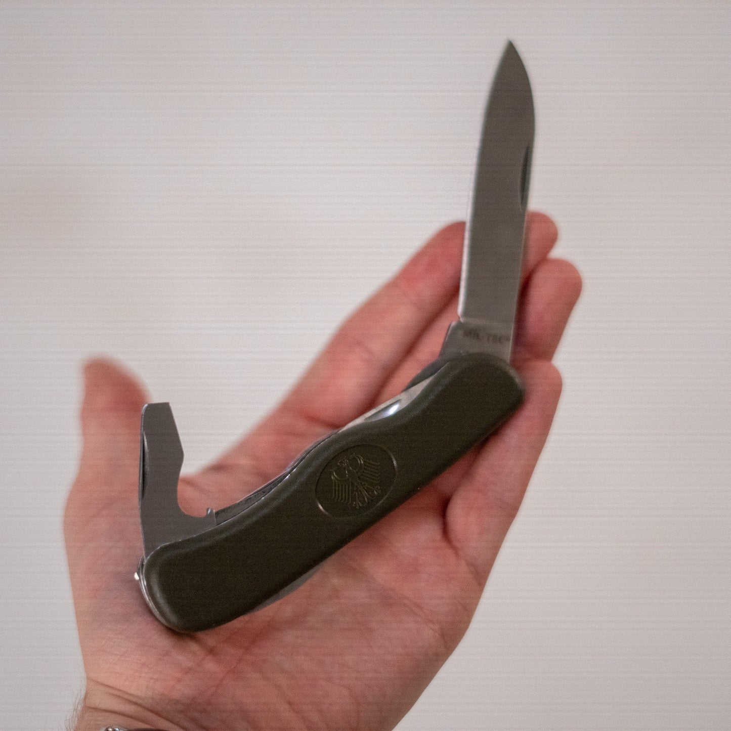 Mil-Tec M2000 Bundeswehr pocket knife with black handle and stainless steel blade, shown on a plain background.