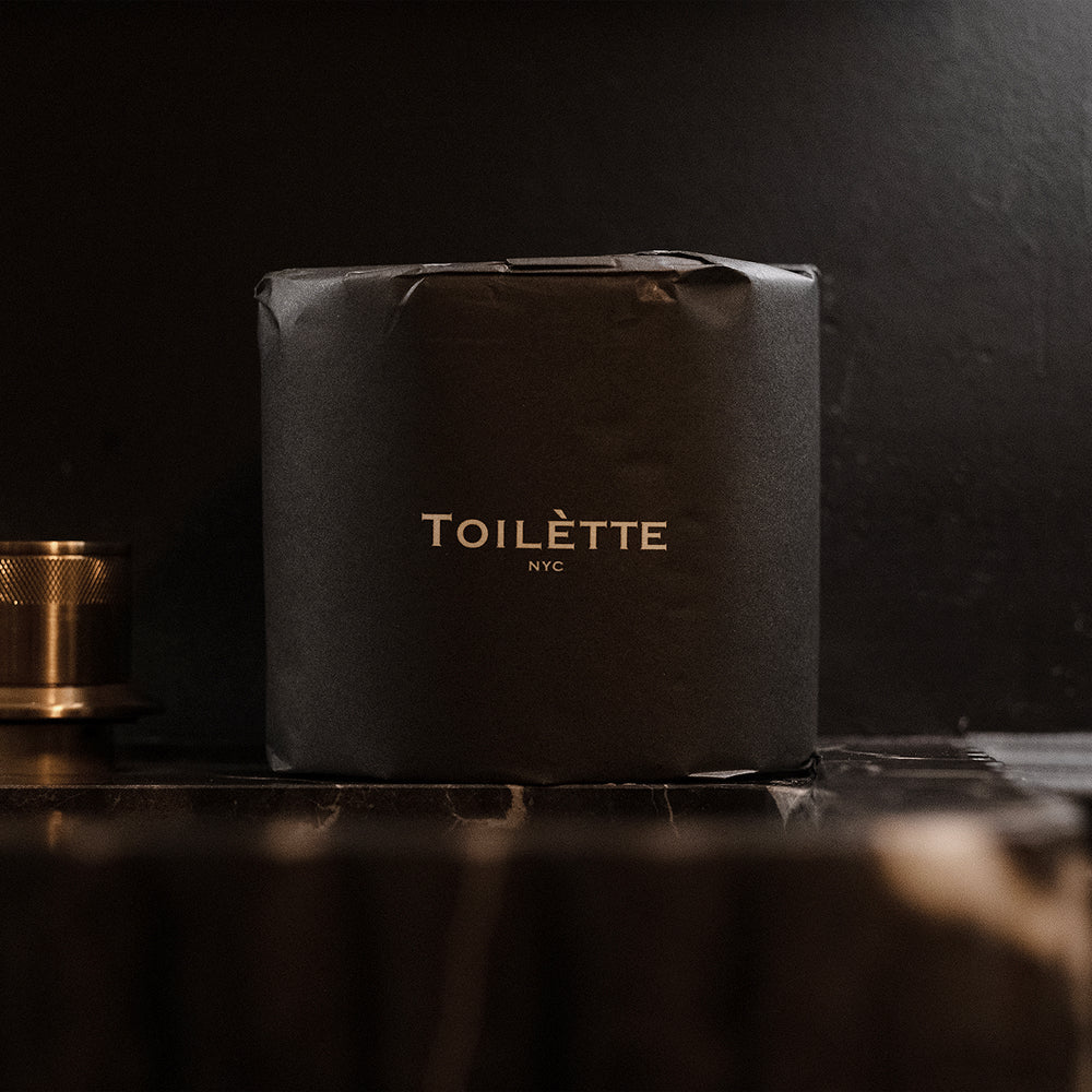 Toilètte brand toilet paper rolls stacked, showing soft, white toilet tissue on a clean bathroom surface.
