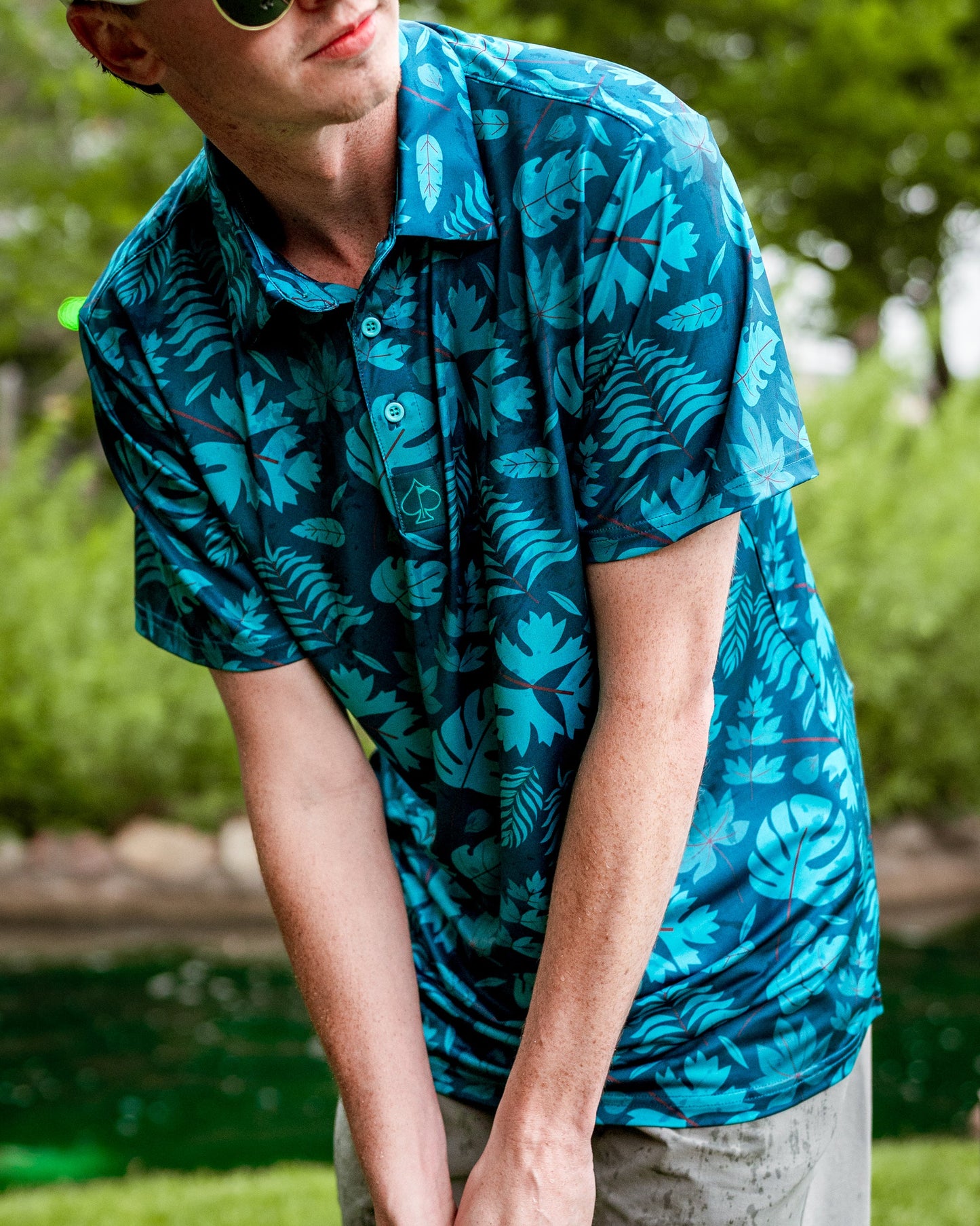 Men's Cabana Nights polo shirt by Pins and Aces, featuring a colorful tropical print and classic polo collar.