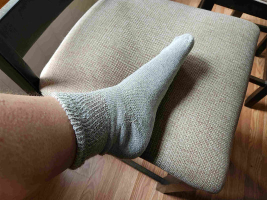 Women's DSC cotton ankle socks in grey, shown sitting.