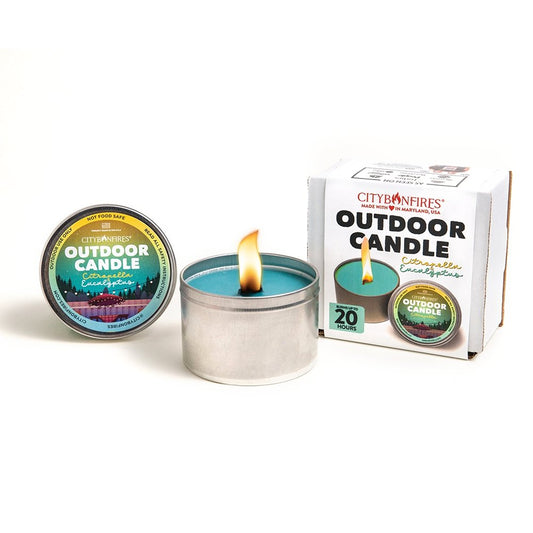 Outdoor candle by City Bonfires with citronella and eucalyptus scent, shown in a natural outdoor setting with a lit flame.